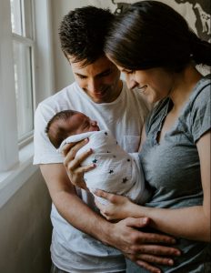 Husband and wife holding newborn baby